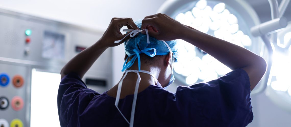 Female surgeon wearing surgical mask in operation theater at hos
